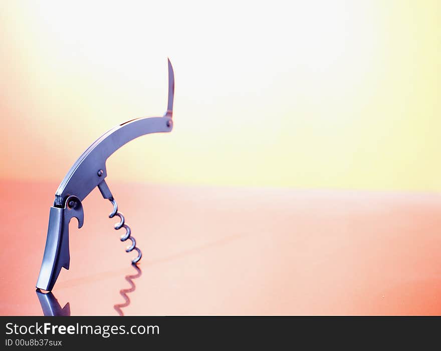 A metal corkscrew on the orange background / copyspace