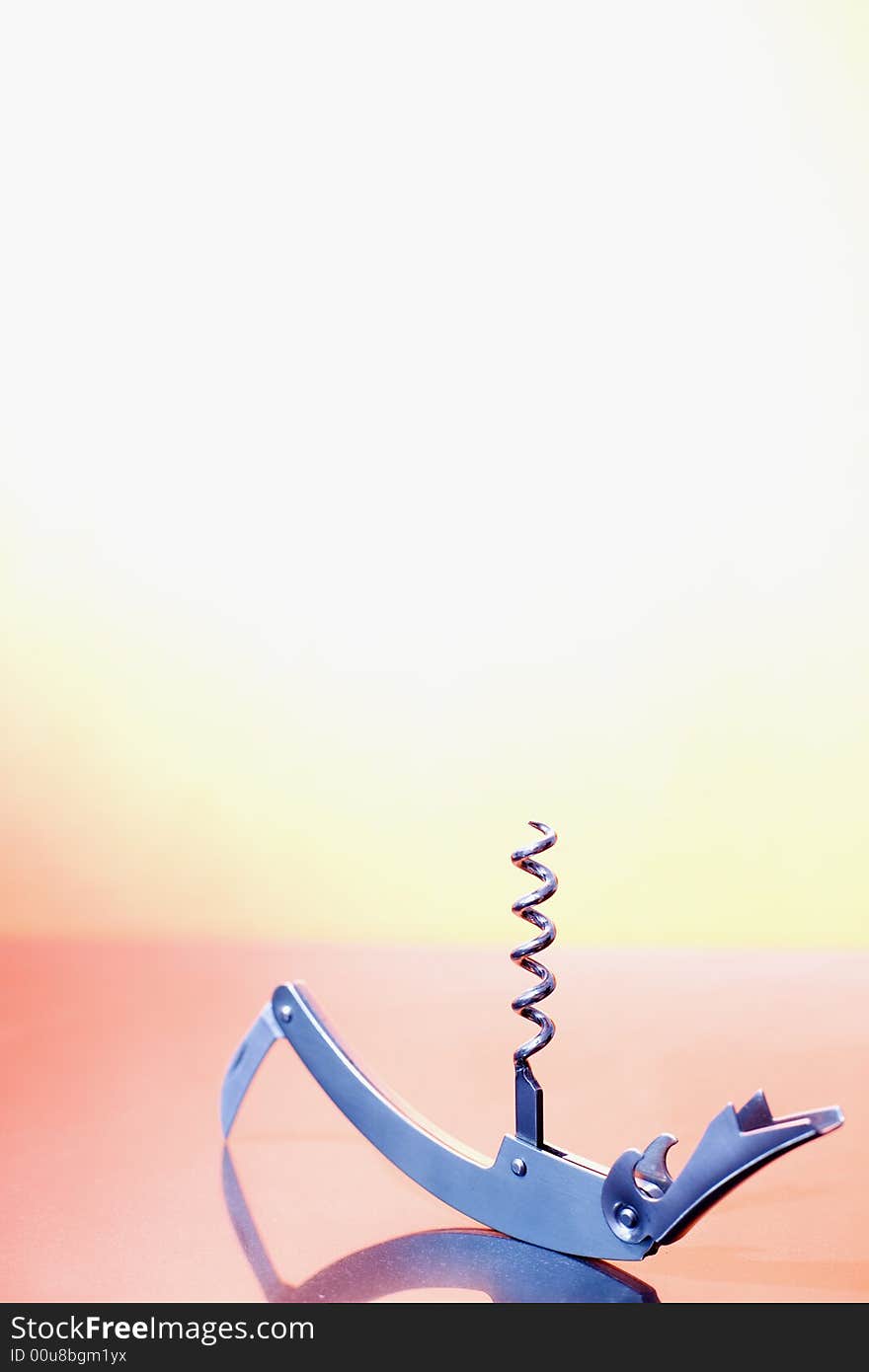 A metal corkscrew on the orange background / copyspace