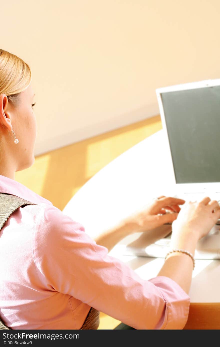 A successful business woman is working on a table with a laptop