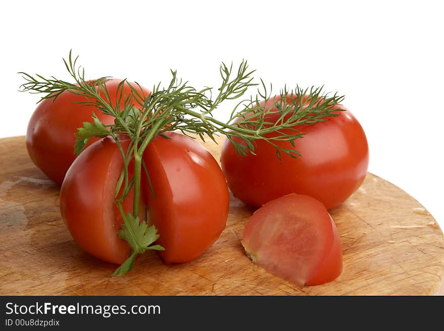 Three tomatoes with fennel on table