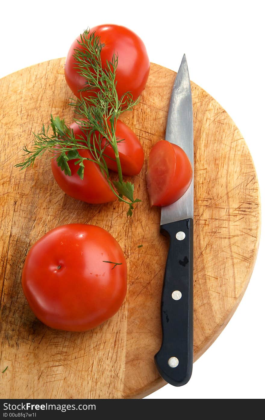 Three tomatoes and knife on  little table