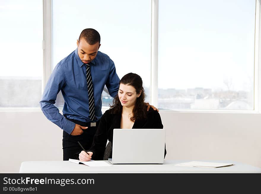 Male and female business partners in a window office. Male and female business partners in a window office