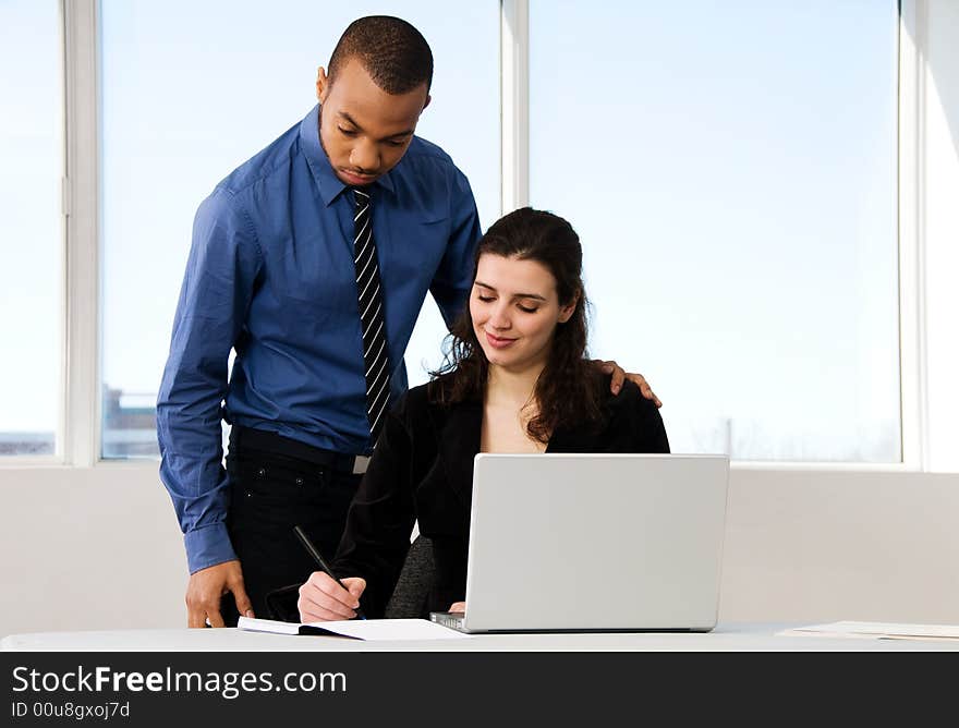 Male and female business partners in a window office. Male and female business partners in a window office