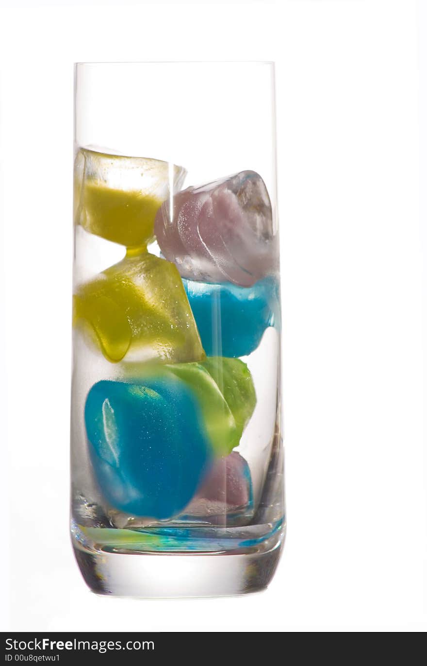 A glass of colored ice cubes over a white background. A glass of colored ice cubes over a white background