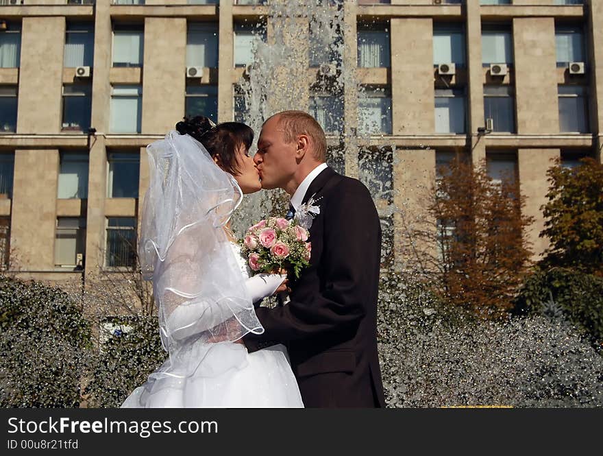 Portrait of the a newly wedded couple kissing