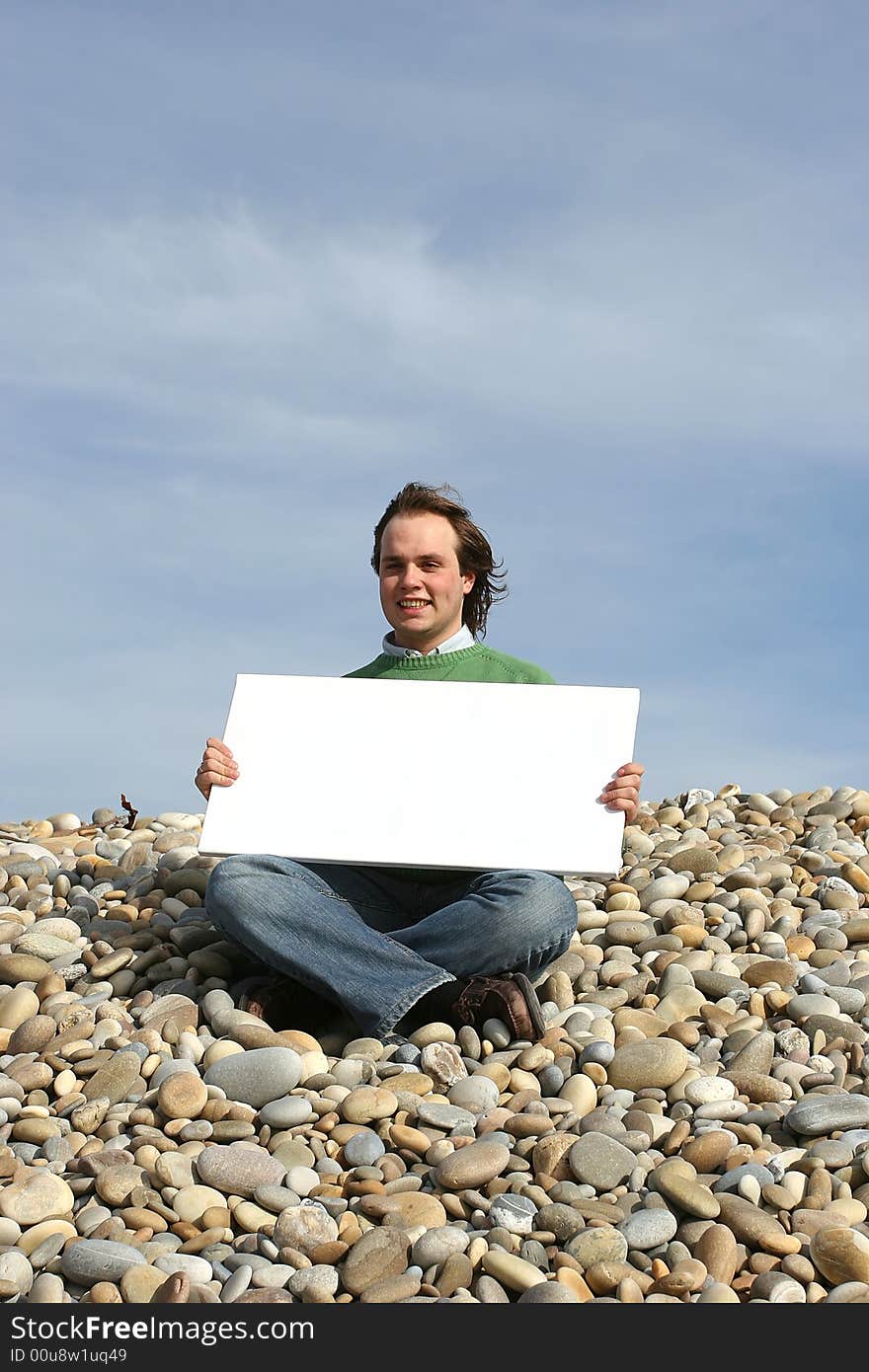 Young Man Holding White Card at the beach