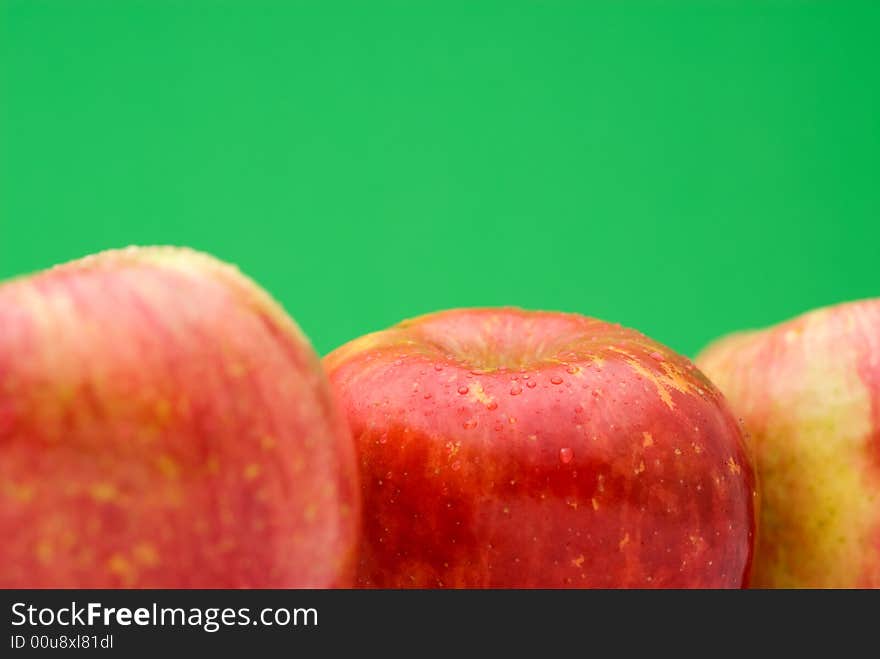 Fresh red apples on a bright green background with shallow focus. Fresh red apples on a bright green background with shallow focus