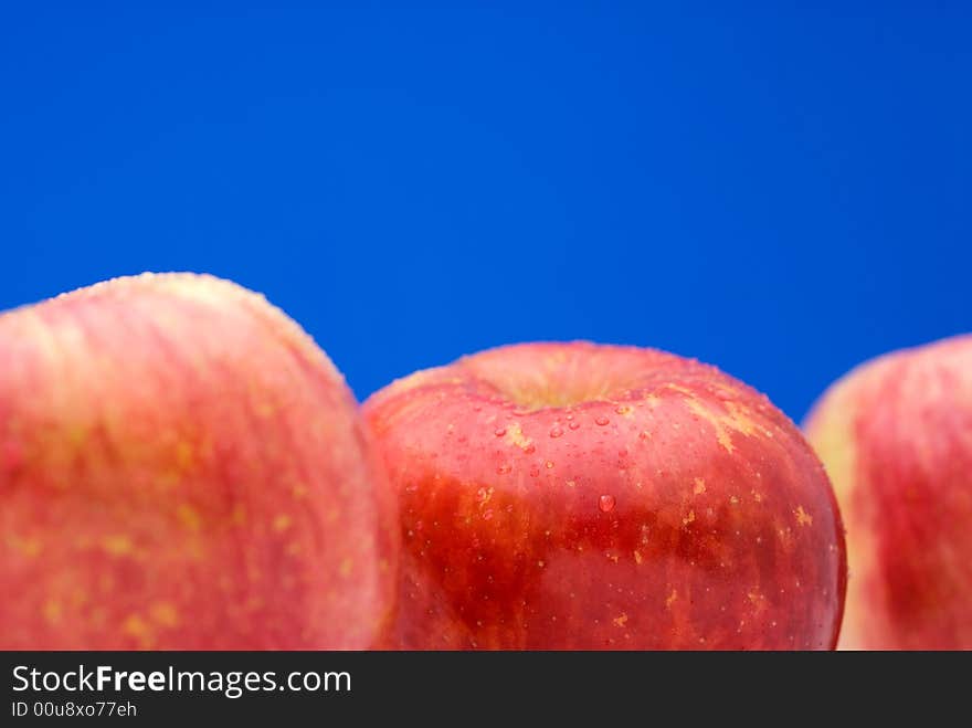 Fresh red apples on a bright blue background with shallow focus. Fresh red apples on a bright blue background with shallow focus