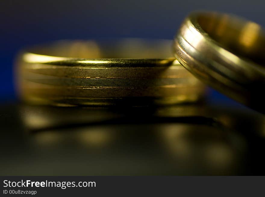 Two golden rings on black with blue background