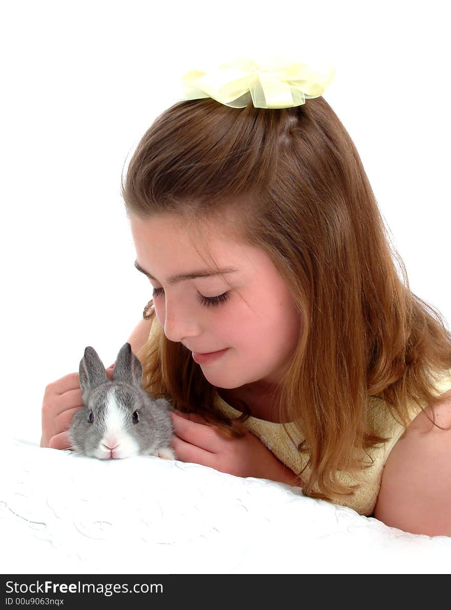 School aged girl gently petting soft gray bunny. School aged girl gently petting soft gray bunny