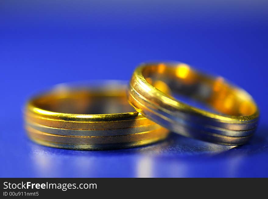 Two golden rings on blue with blue background