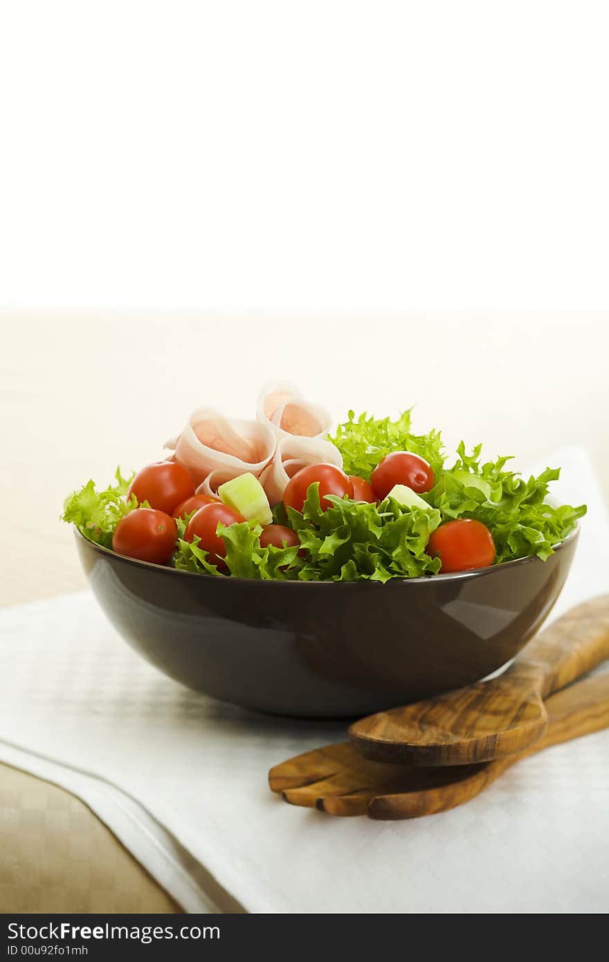 Prosciutto salad with wooden spoon on the table