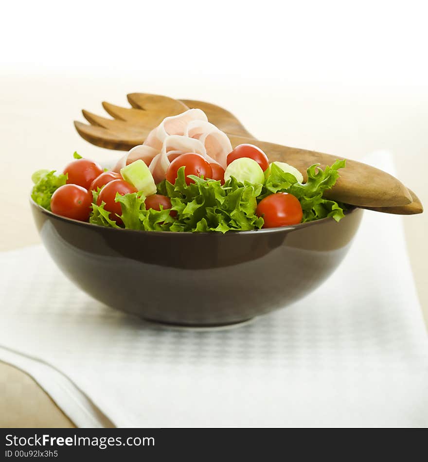 Prosciutto salad with wooden spoon on the table