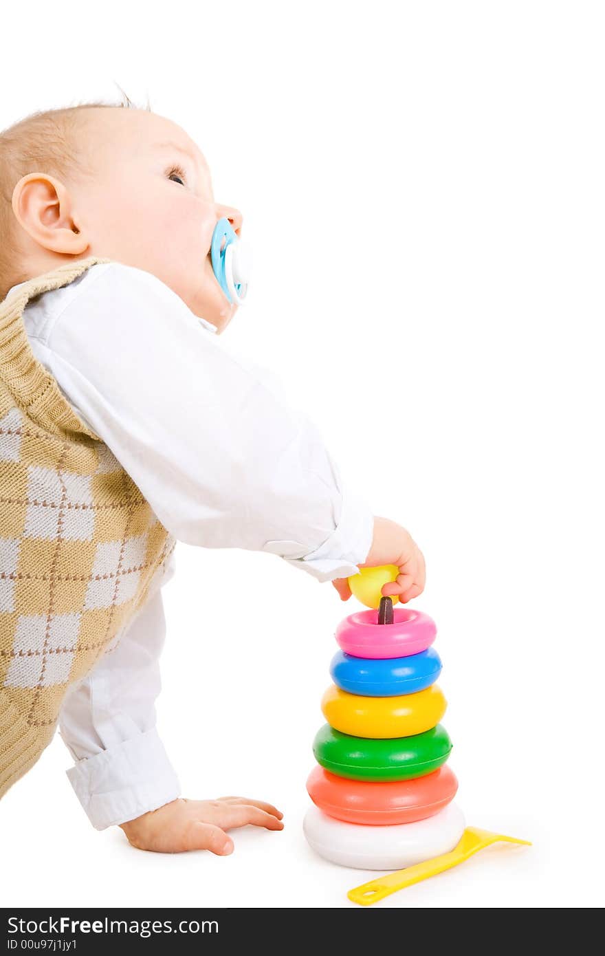 The toddler boy plays developing game. Color pyramidon.