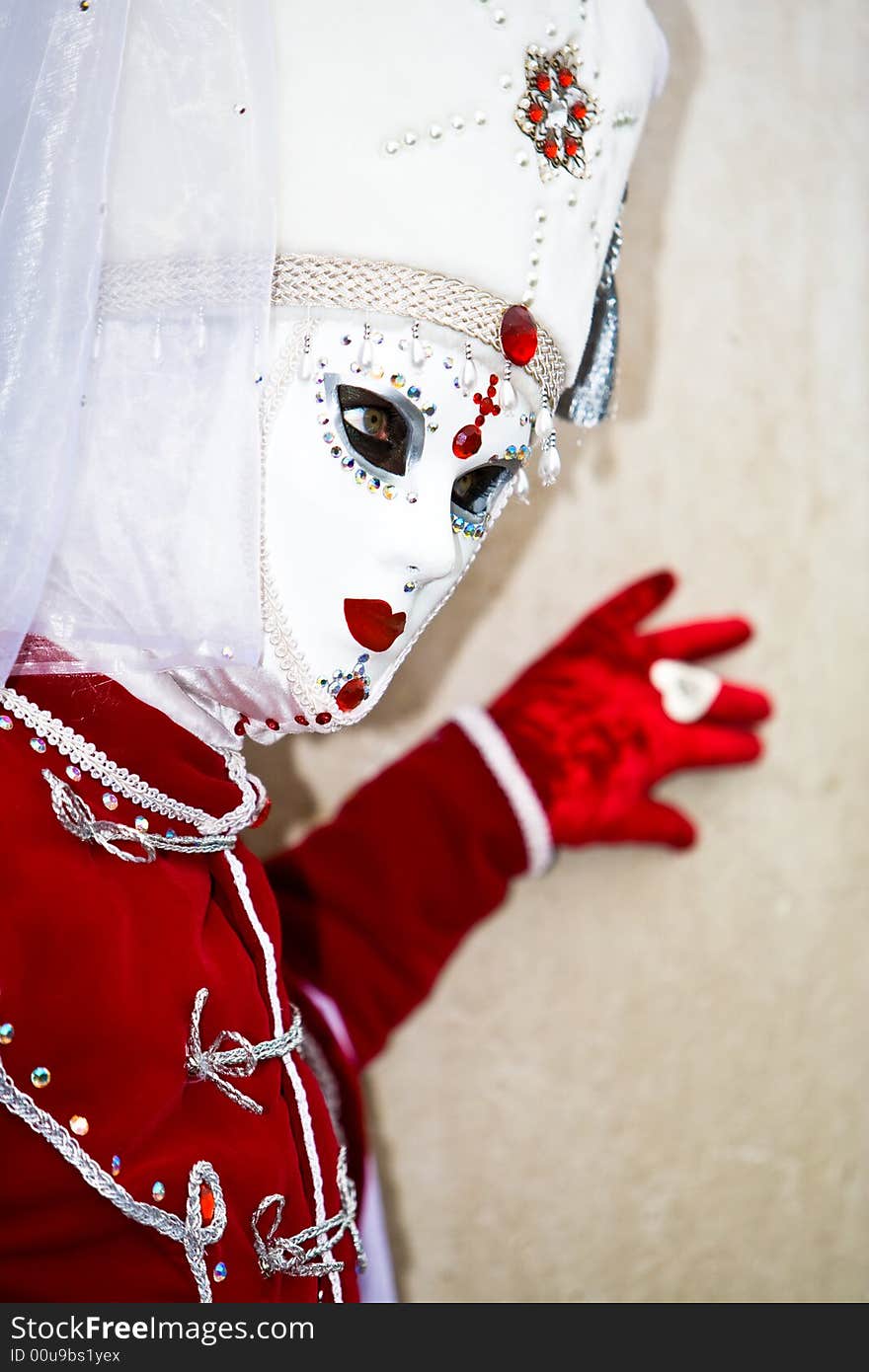 Red velvet costume and a white mask in Venice. Red velvet costume and a white mask in Venice