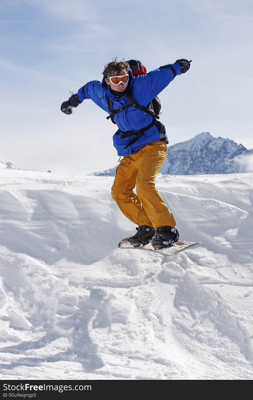 Snowboarder taking a jump in fresh snow