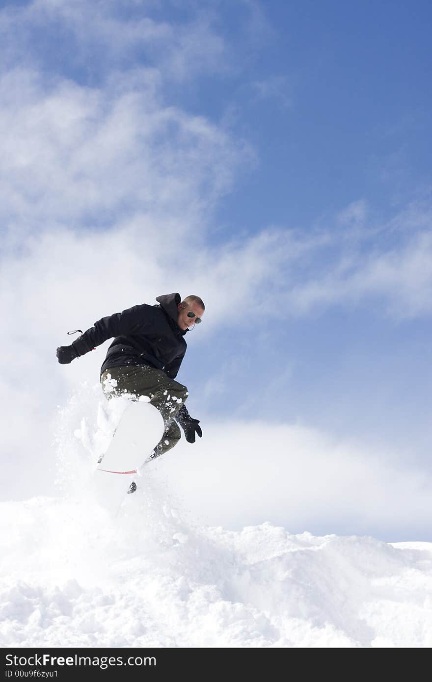 Snowboarder taking a jump in fresh snow