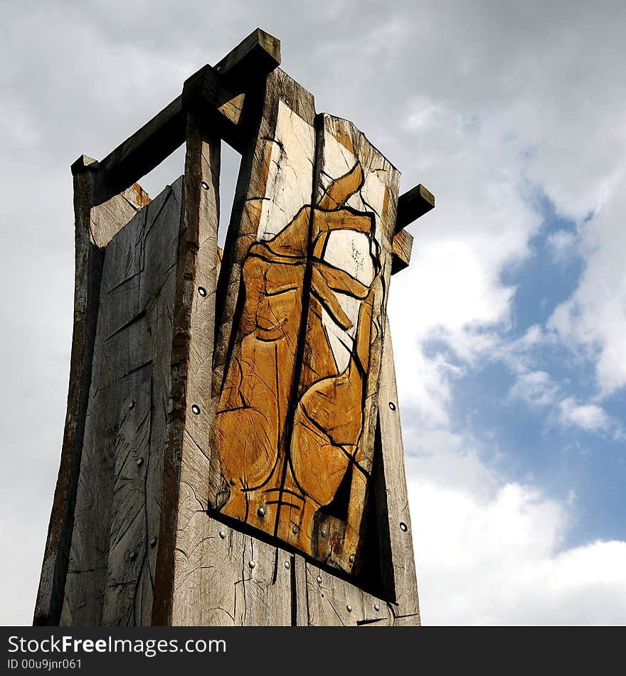 A view with an abstract wood sculpture outdoor representing a hand againts sky. A view with an abstract wood sculpture outdoor representing a hand againts sky