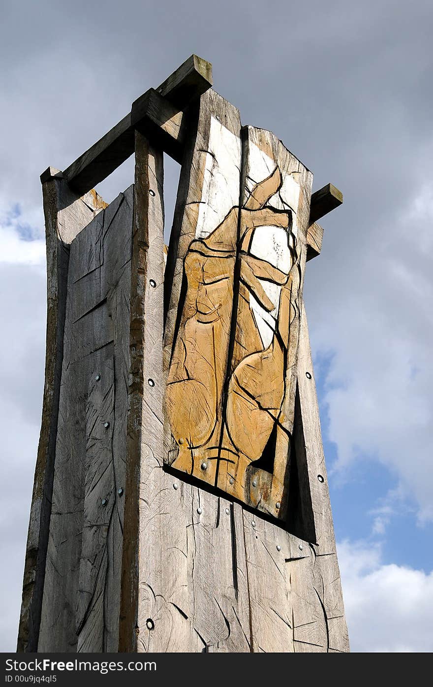 A view with an abstract wood sculpture outdoor representing a hand againts sky. A view with an abstract wood sculpture outdoor representing a hand againts sky