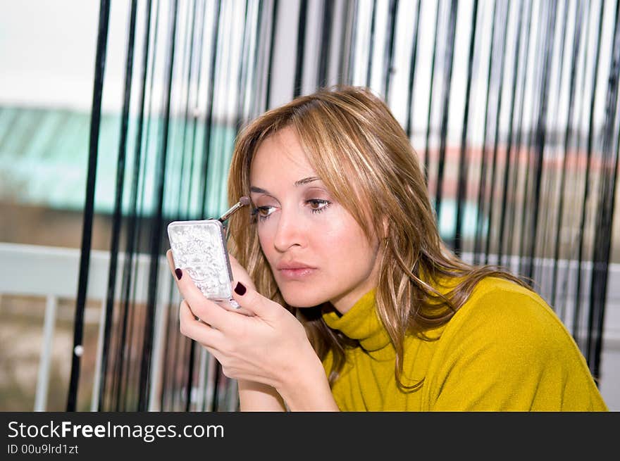 Woman applying cosmetic with applicator. Make-up treatment. Woman applying cosmetic with applicator. Make-up treatment.