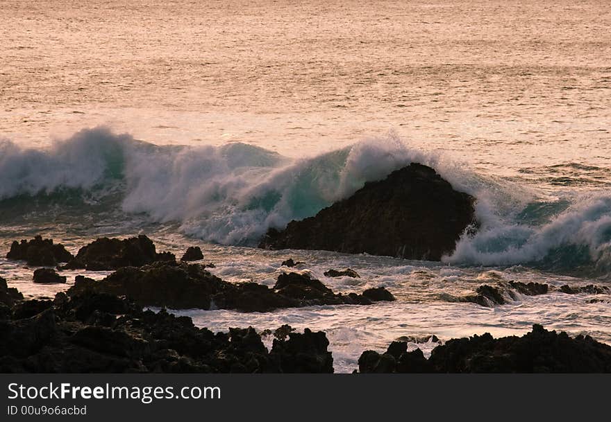 Crashing waves on rock in sunset