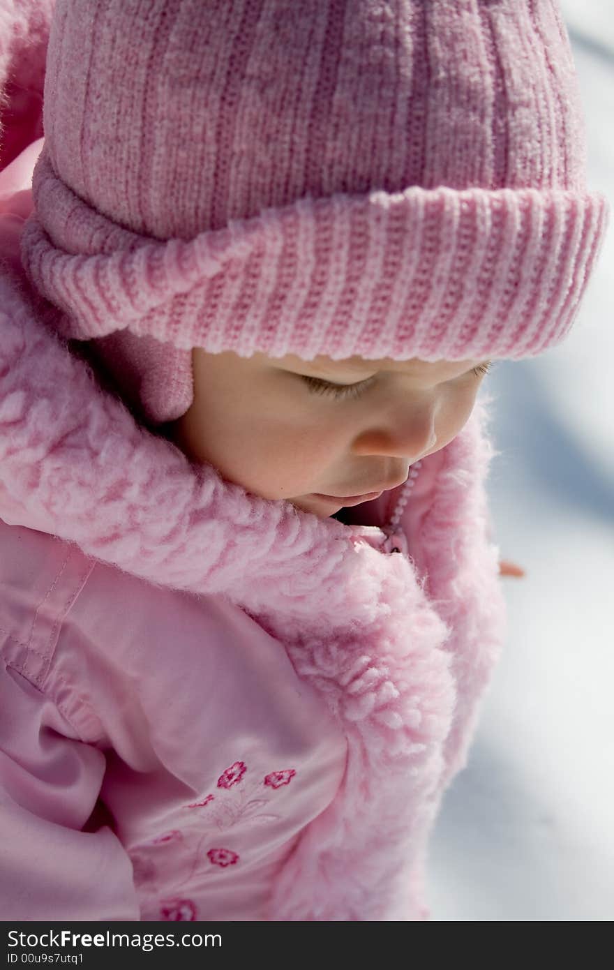 Young girl dressed in pink hat and coat outside in the snow. Young girl dressed in pink hat and coat outside in the snow.