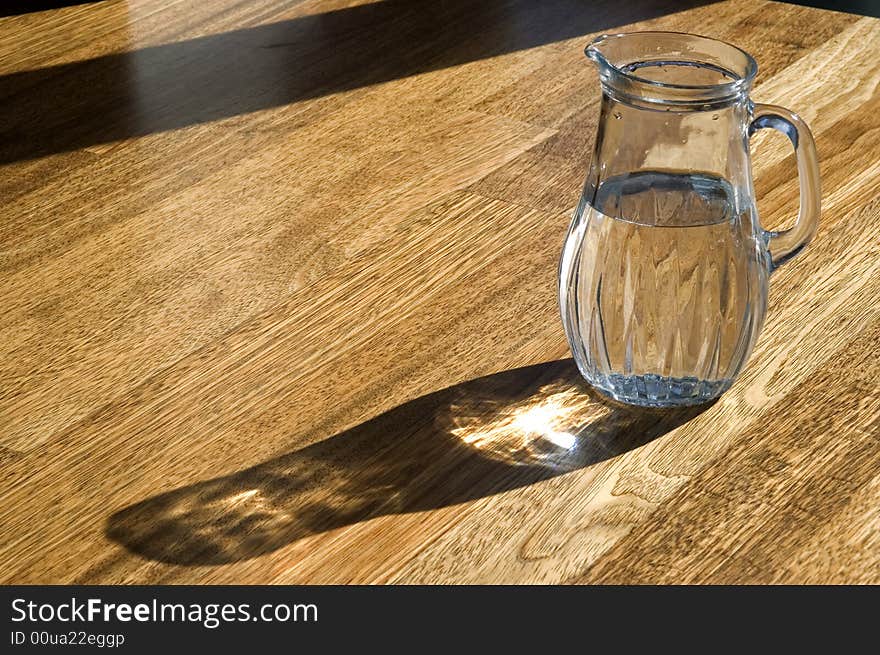 Decanter with water on a wooden floor. Decanter with water on a wooden floor.