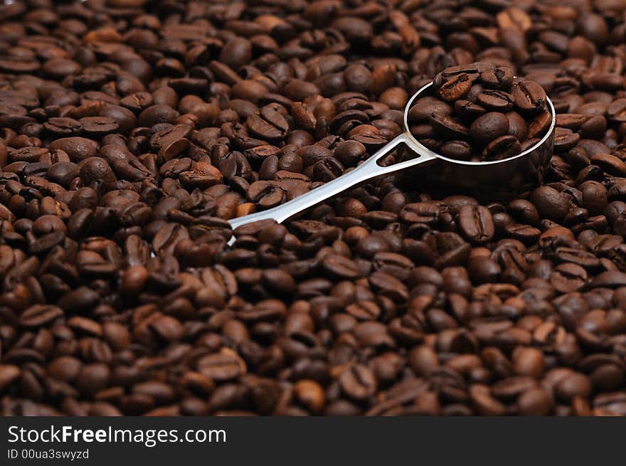 Coffee spoon lying on coffee beans. Coffee spoon lying on coffee beans