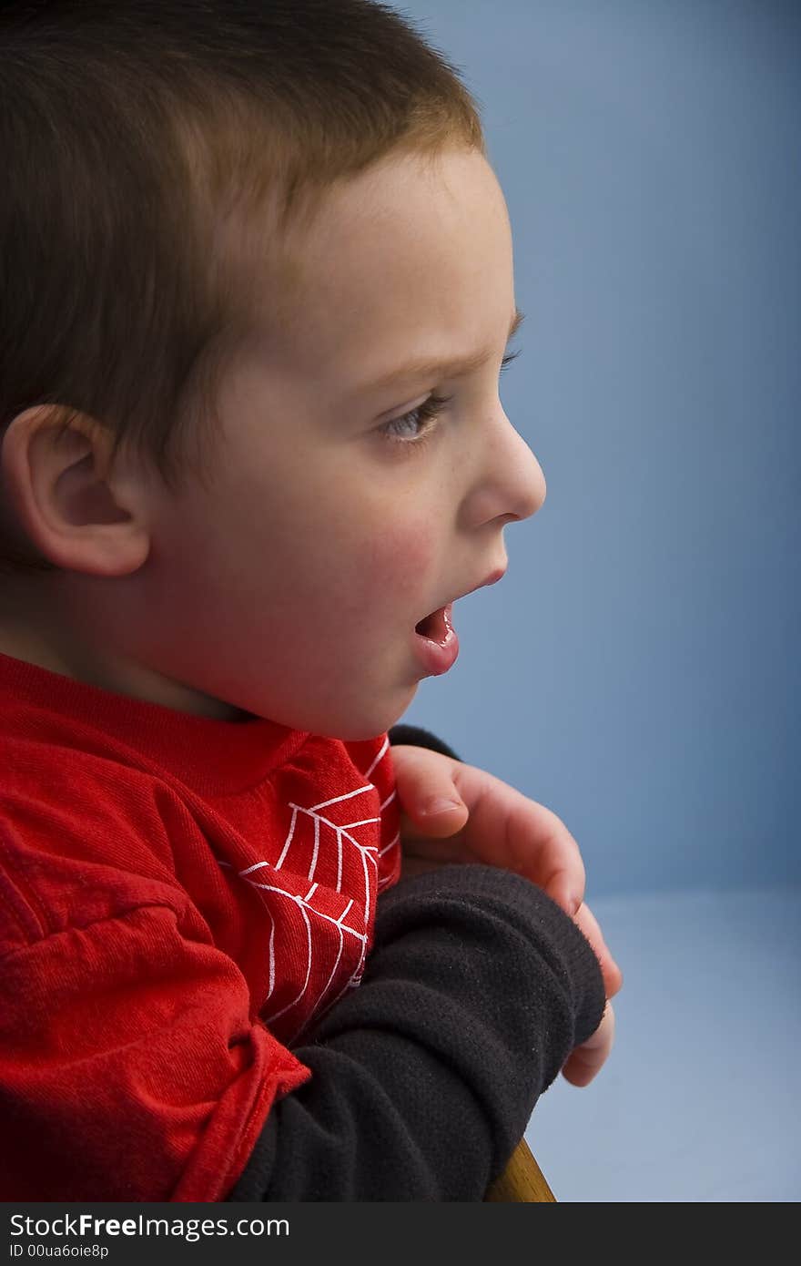 Young boy look out window looking surprised. Young boy look out window looking surprised.