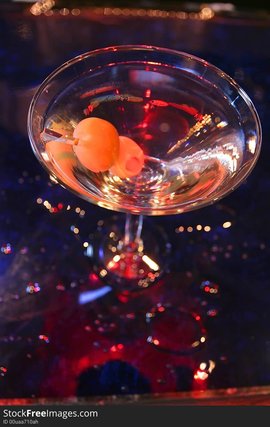 An image of a martini with olives