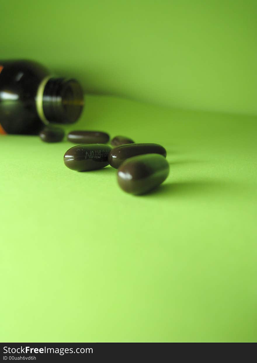 A bottle of pills on a green background