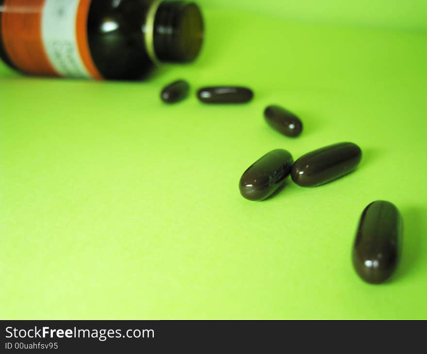 A bottle of pills on a green background