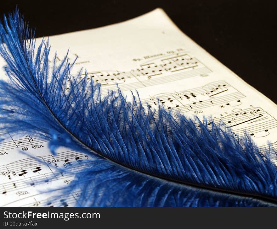 Piano sheets with blue feather