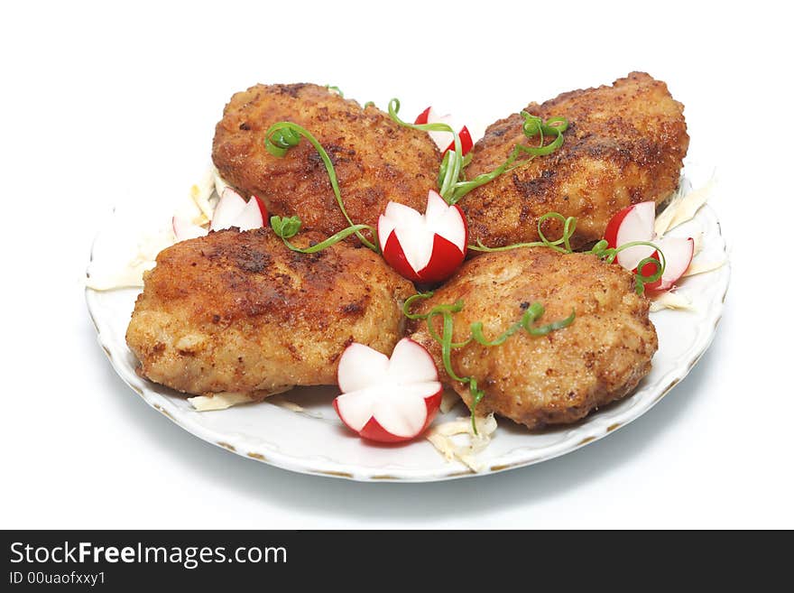 Meat rissoles with garden radish on a white round plate