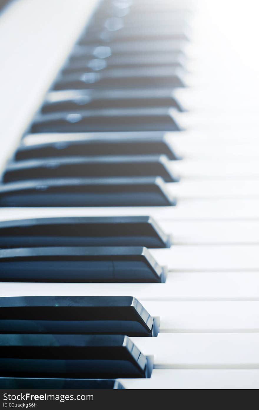 View of piano keys in sunlight with lens flare and low depth of field.