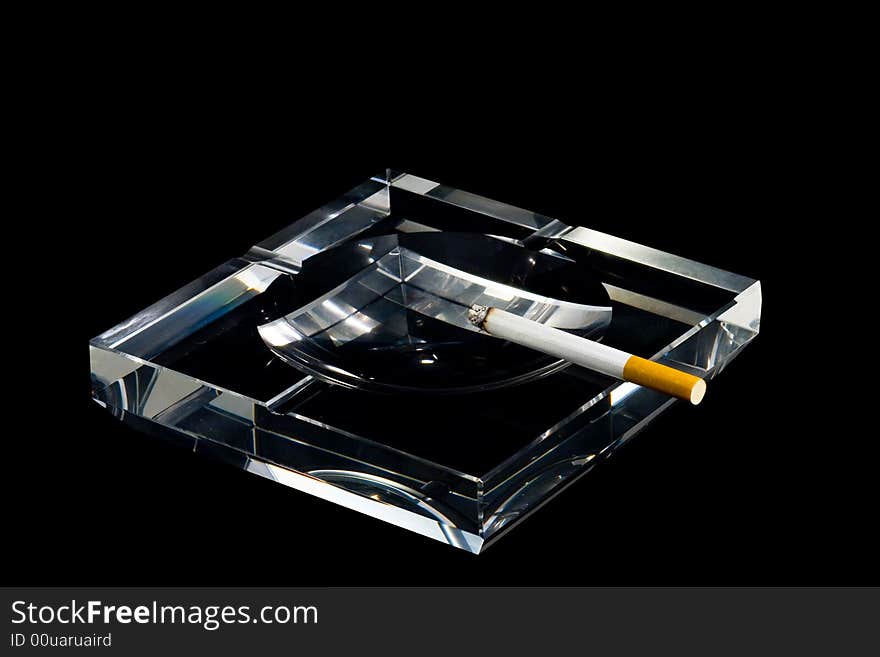 A crystalline ashtray and a cigarette. A crystalline ashtray and a cigarette