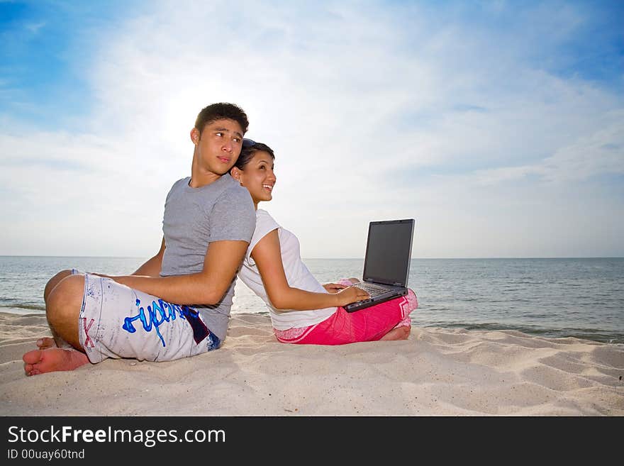 Couple Sitting On The Beach Relaxing