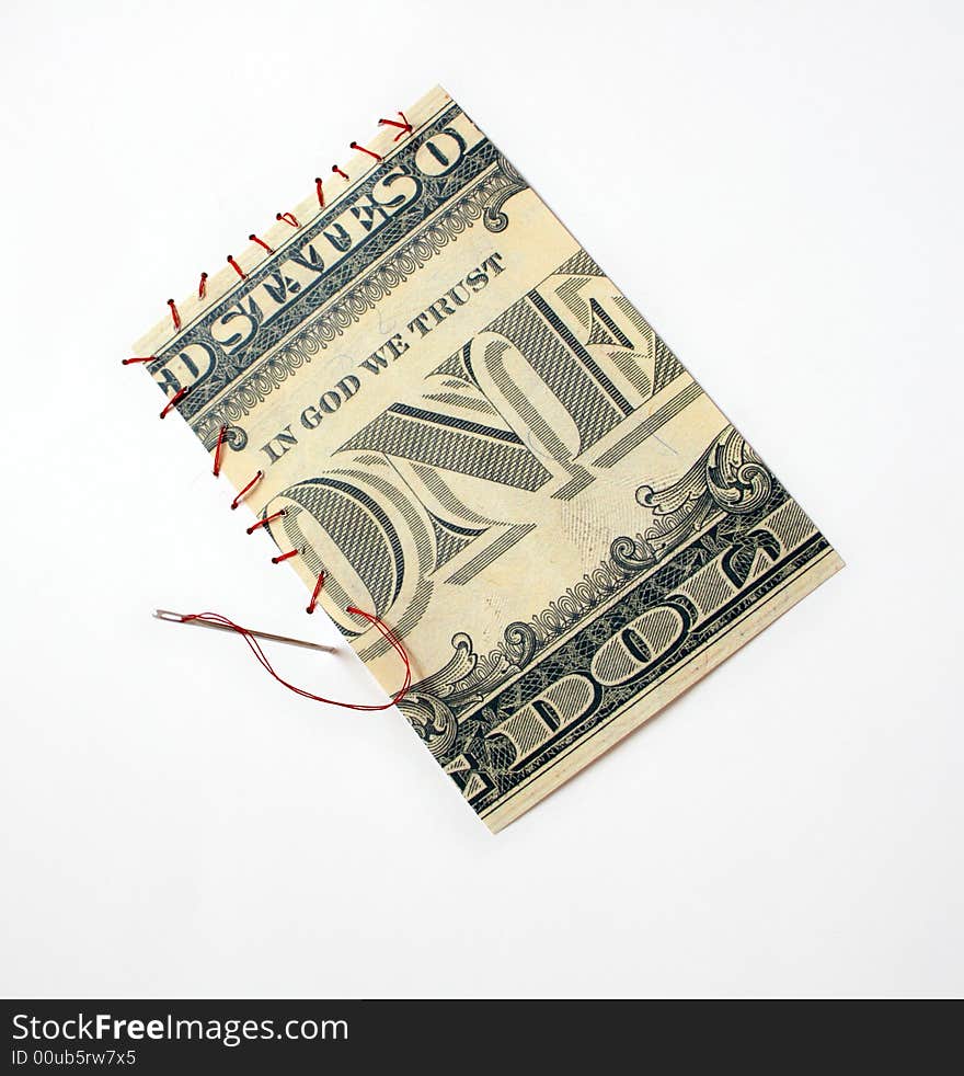 Fragment of one dollar bill sewing with red thread and steel needle to white background. Fragment of one dollar bill sewing with red thread and steel needle to white background