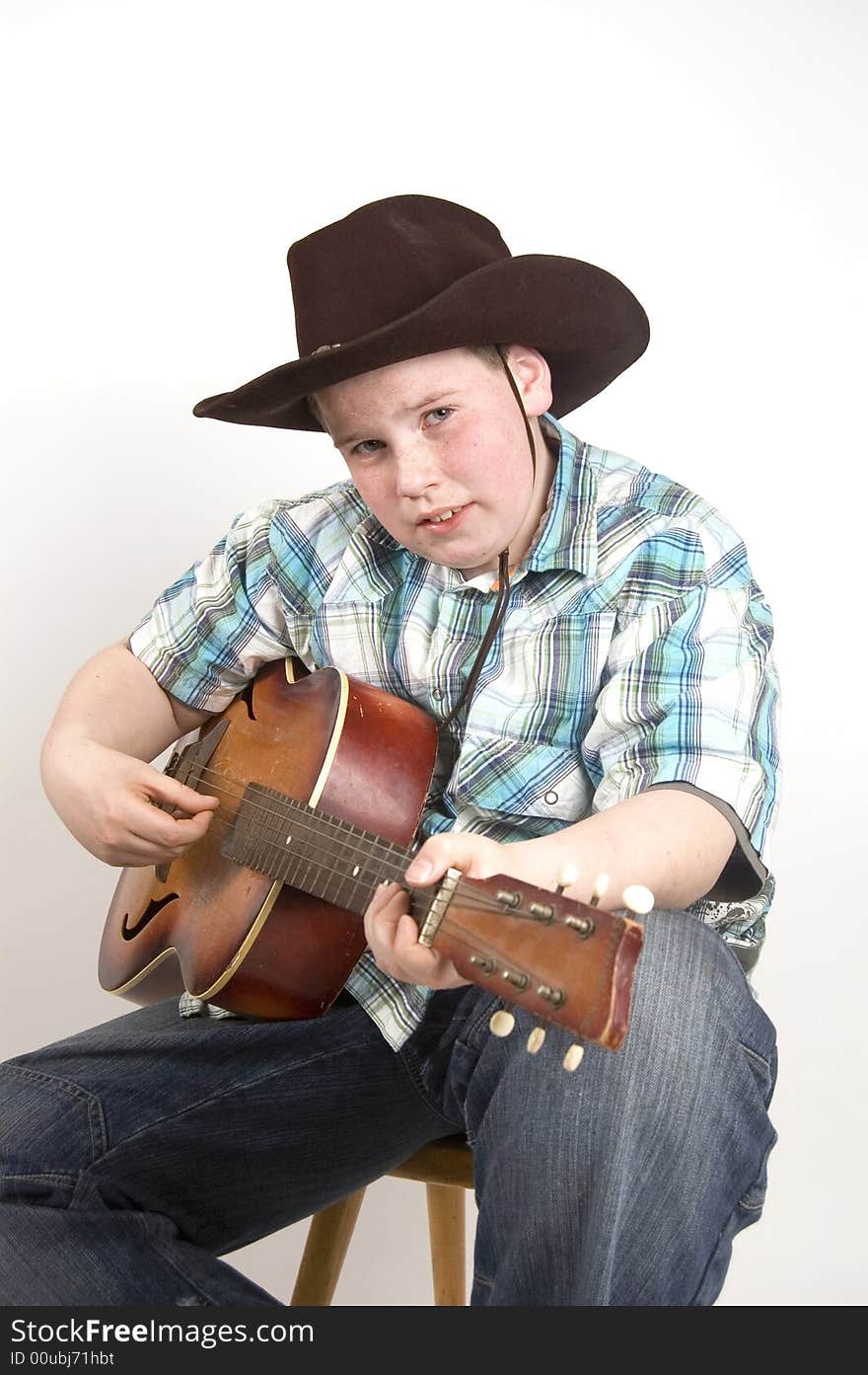 Young cowboy playing the guitar