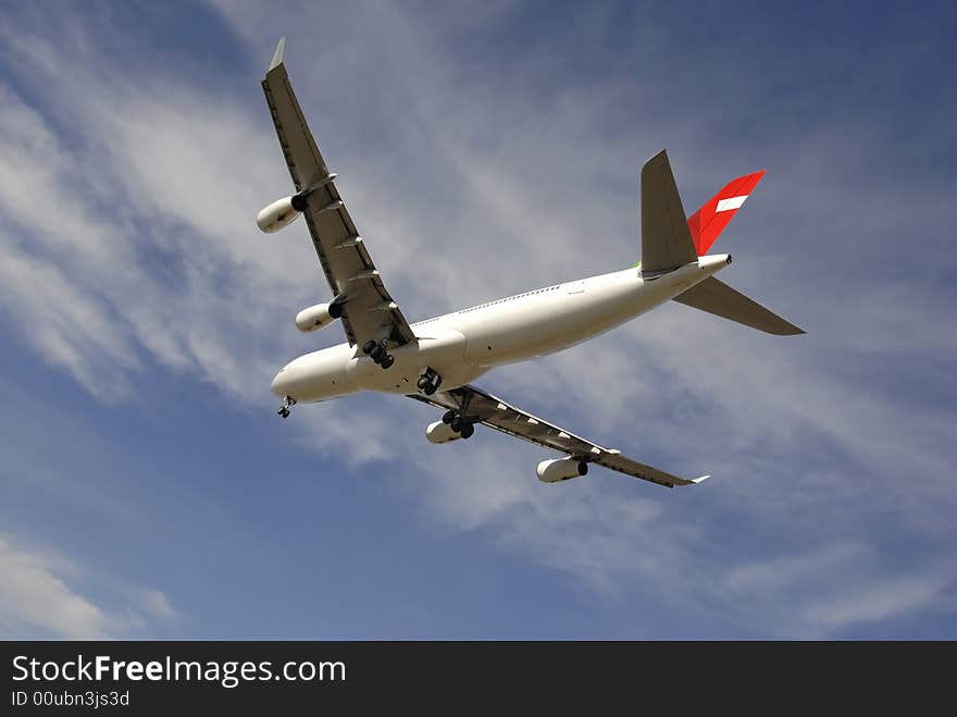 Modern passenger jetliner landing against blue sky