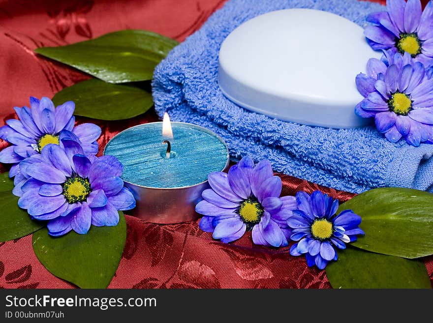 Spa essentials, soap, towel and candle with flowers