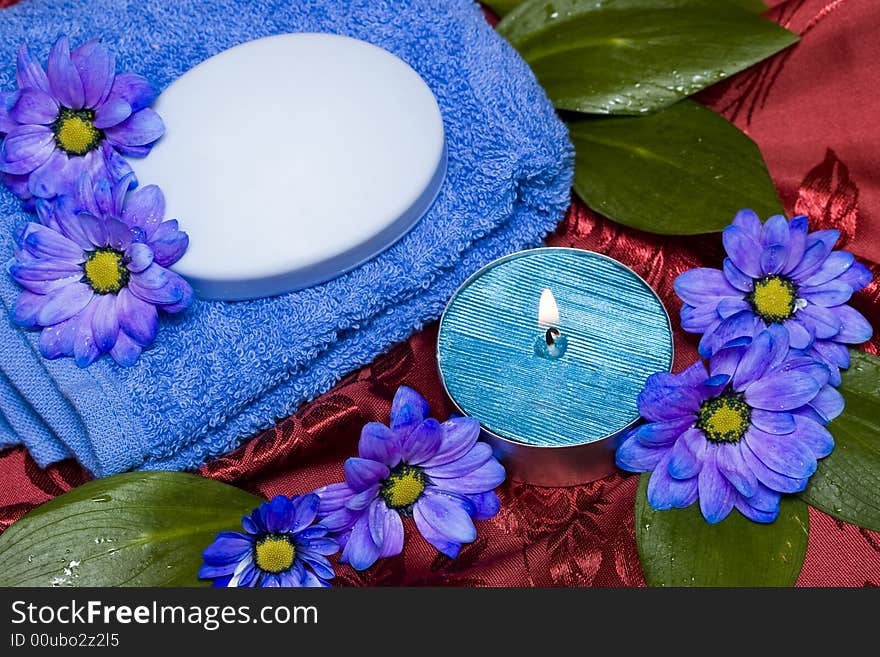 Spa essentials, soap, towel and candle with flowers