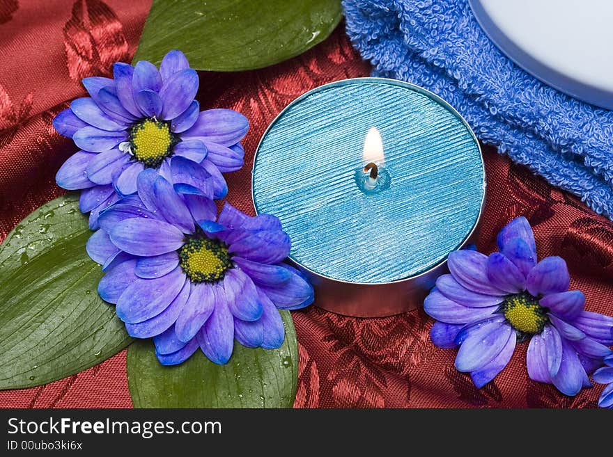 Spa essentials, soap, towel and candle with flowers