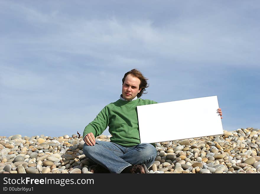 Young Man Holding White Card at the beach