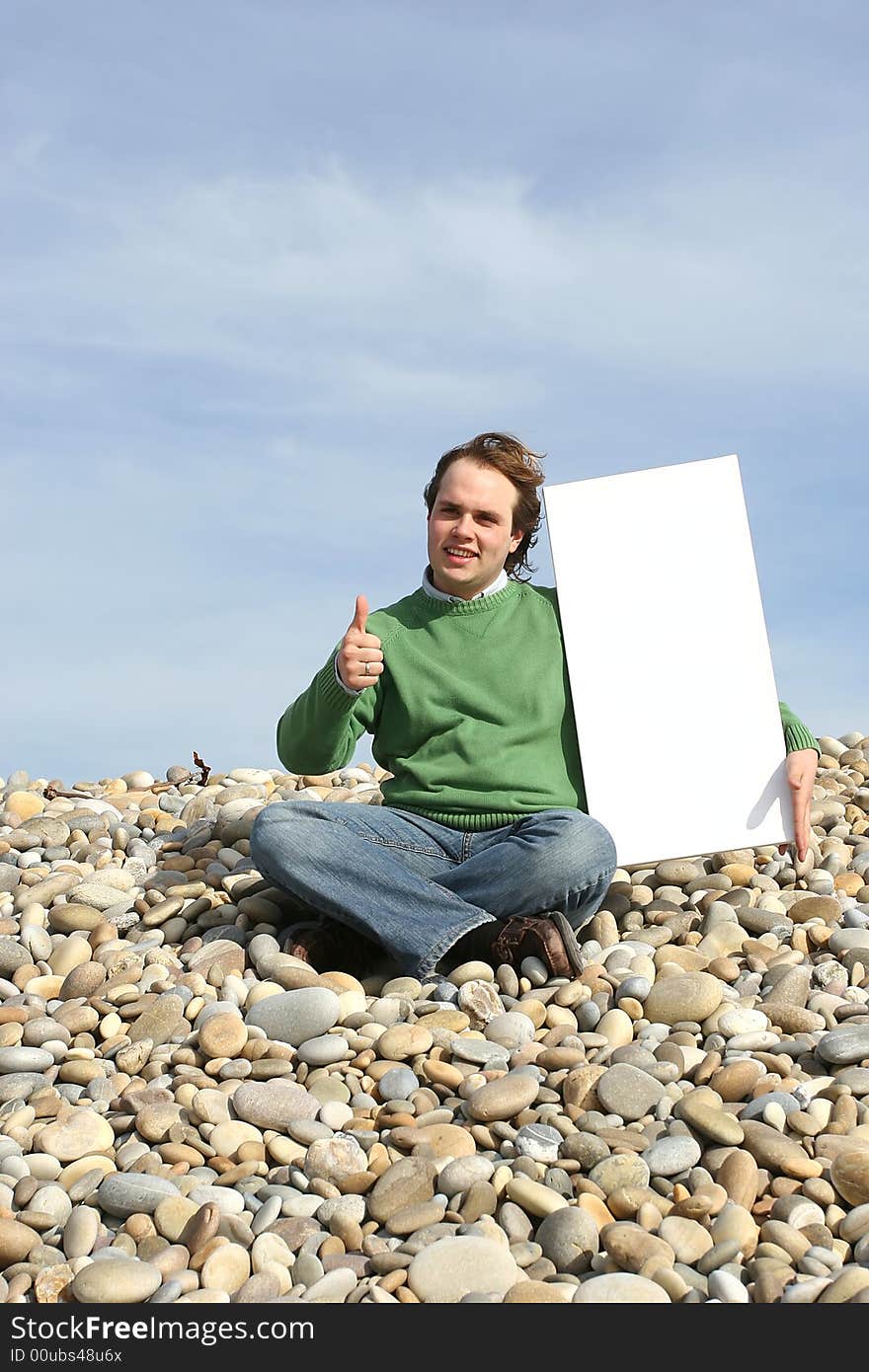 Young Man Holding White Card at the beach