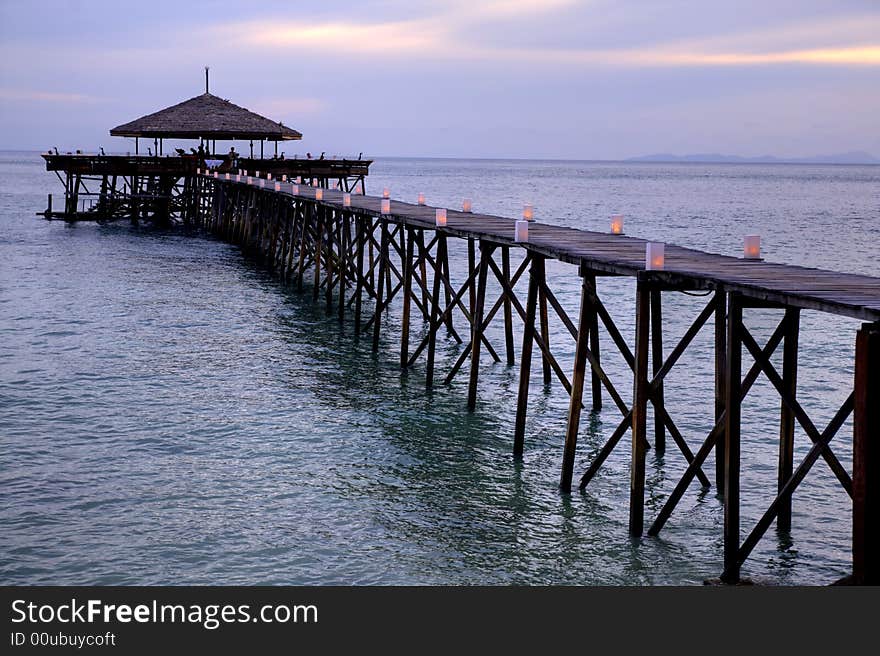 A restaurant placed on poles a god way out in the ocean. A restaurant placed on poles a god way out in the ocean.