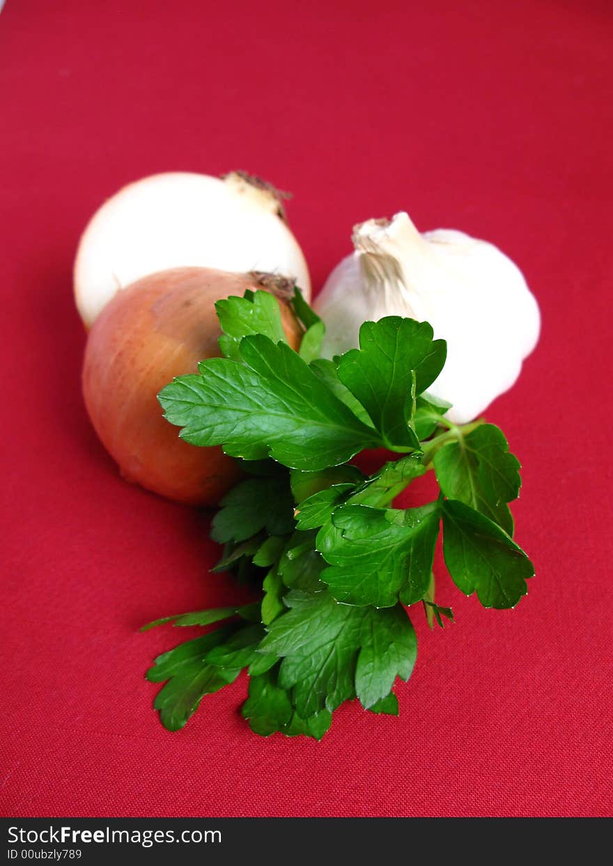 Bouquet of parsley tied with a white rope, Onion and Garlic, in red background. Bouquet of parsley tied with a white rope, Onion and Garlic, in red background.