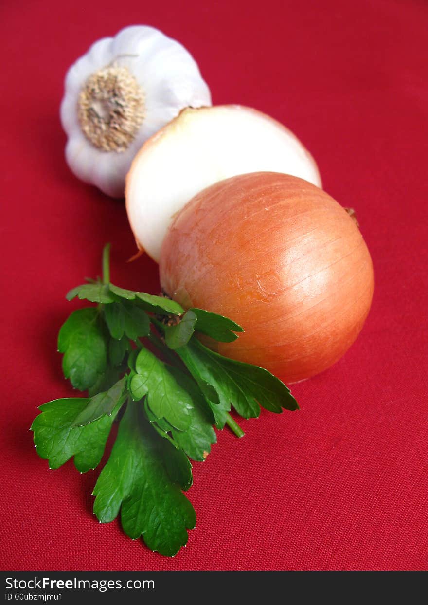 Bouquet of parsley tied with a white rope, Onion and Garlic, in red background. Bouquet of parsley tied with a white rope, Onion and Garlic, in red background.