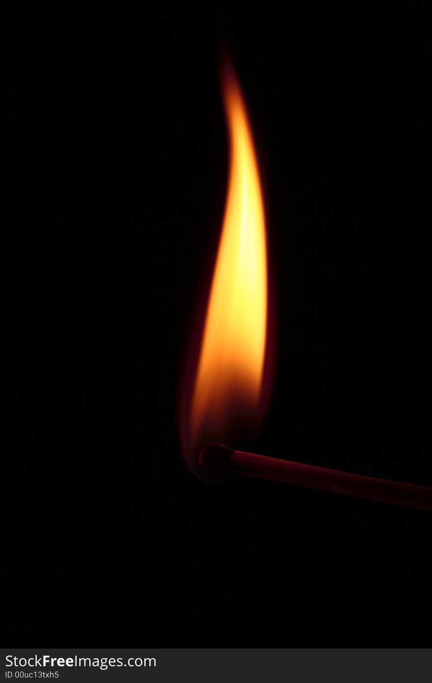 One yellow flame on a black background. One yellow flame on a black background