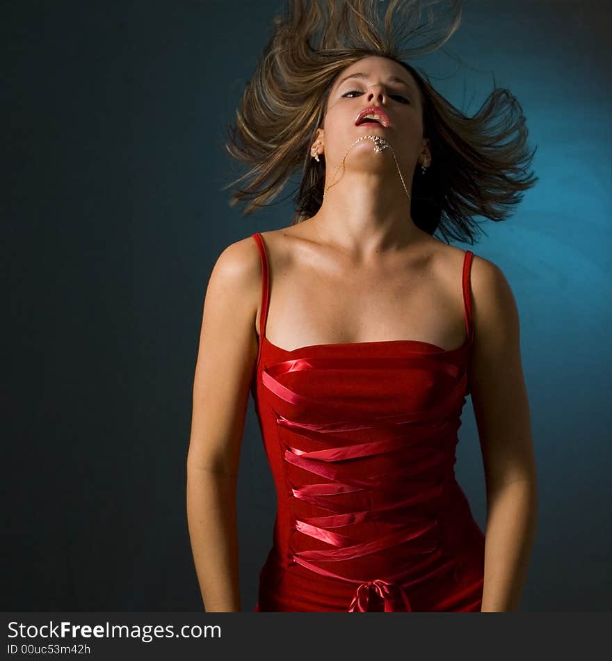 Fashionable woman with red dress waving her hair. Fashionable woman with red dress waving her hair